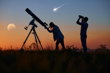 Couple stargazing together with a astronomical telescope, looking at planets, stars, lunar eclipse...