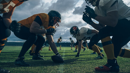 Two Professional American Football Teams Stand Opposite Each Other,  Ready to Start the Game. Defense and Offense Prepare to Fight for the Ball with Desire to Score Points and the Goal and Win. - Powered by Adobe