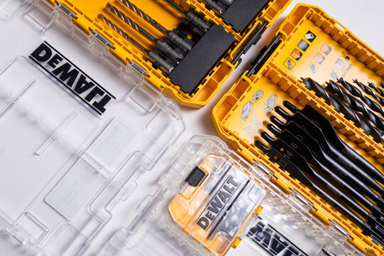 Closeup photo shot of open yellow and transparent kit box with drills for drilling holes and screwdriver isolated on background. Repair and construction concept. Set of tools