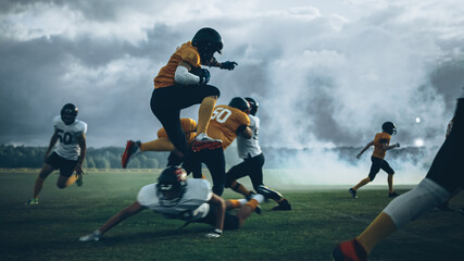 American Football Field Two Teams Compete: Successful Player Jumping Over Defense Running to Score...