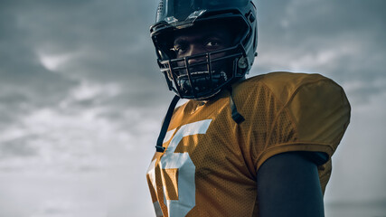 American Football Championship Game: Close-up Portrait of Professional Player Wearing Helmet. Professional Athlete Full of Power, Skill, Determination to Win. Low Angle Shot