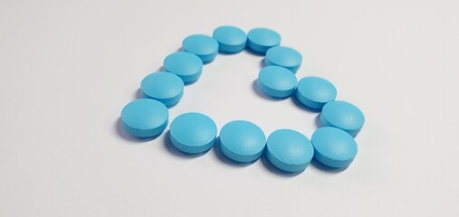 Blue heart made of pills. Heart pills. Vitamins for adults, children, pregnant women. Heart shaped blue pills.