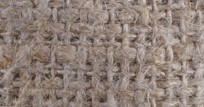 The texture of the burlap is close-up. Macro tissue. Brown background.