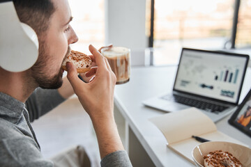 Confident man eating his tasty breakfast during the successful work from home