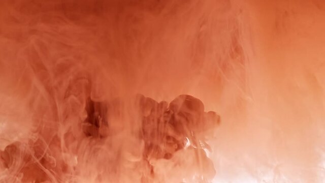 Flow with swirls of pale terracotta color paint in transparent water as decorative abstract background slow motion extreme closeup