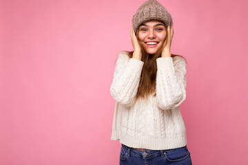 Attractive smiling happy young brunet woman standing isolated over colorful background wall wearing everyday stylish outfit showing facial emotions looking at camera