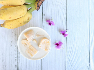 Banana in coconut milk. Asian traditional dessert. Fruit desserts. top view with copy space on wooden table