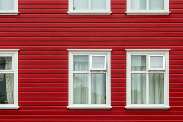 Windows on a red painted wall, colorful house, architecture detail in Reykjavik, Iceland