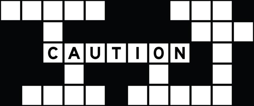 Alphabet letter in word caution on crossword puzzle background