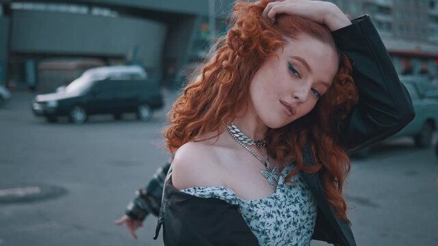 Pretty curly ginger woman shaking into music dancing hanging out with best friends outdoors. Motorbike. Biker girls. Hipster party. Urban lifestyle.