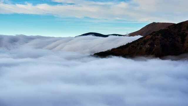 Cloud inversion, clouds spill over the mountain,