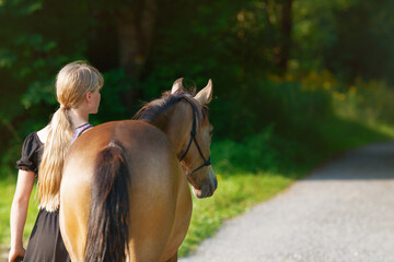 Mädchen geht mit jungem Pferd spazieren