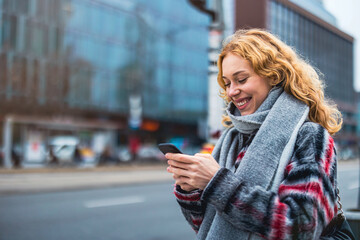 Young woman in the city checking her mobile phone
