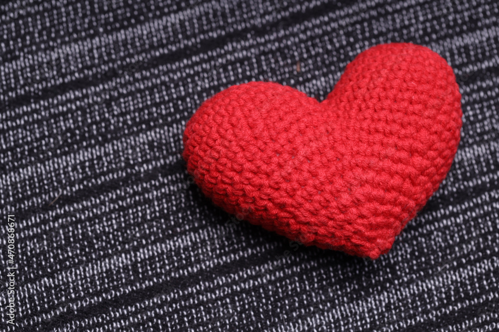 Sticker beautiful heart lies on a gray knitted background. Love concept