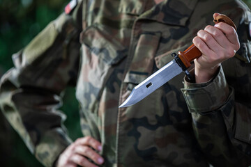 A woman dressed as a soldier holds a bayonet in her hand. The equipment of each soldier.