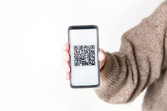Adult man holding a smartphone with a QR-code. Virtual immunity passport or international certificate of vaccination. Contactless payment. Close-up