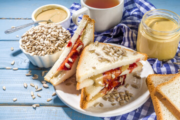 Traditional American breakfast sandwich toast with alternative not nut butter - sunflower seeds paste and vegan organic jam. Healthy alternative non-allergenic food concept copy space