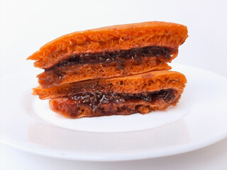 Kue Terang Bulan from Semarang, Indonesia. Popular street food, similar to pancake, with various filling (chocolate, strawberry jam, or refined sugar). On a white plate, isolated on white background