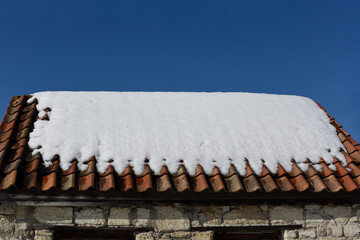 The sloping roof of the house, covered with a thick layer of snow. Symbol for Christmas holidays. House insulation