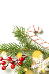 Festive natural, zero-waste, plastic-free, Christmas decoration on white with copy space. DIY winter holidays home decor made of traditional homemade biscuits, fir branches, pine cones and red berries