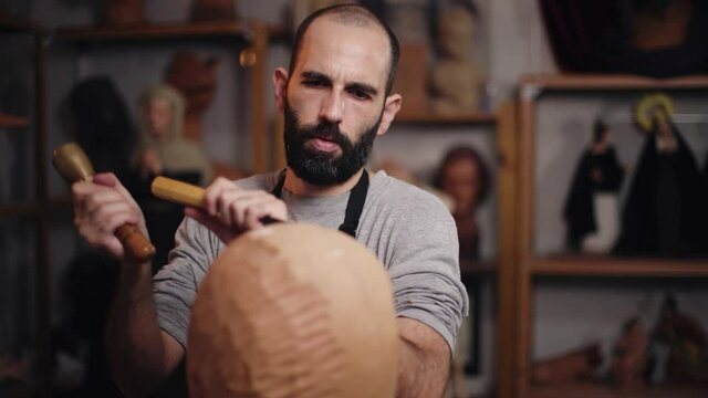 Focused craftsman shaping wooden detail with chisel