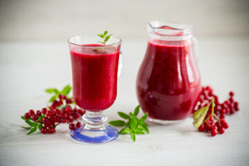 freshly squeezed thick natural juice with pulp from ripe red viburnum in a decanter