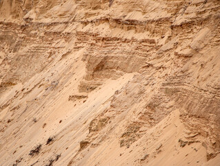 Textural sand, with  relief surface, multi-colored layers and different in size of granules, in outdoor sand career, after mining ore and sand for construction.