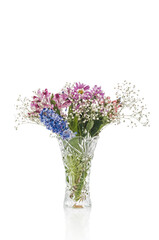 Bouquet of flowers in crystal vase on white background