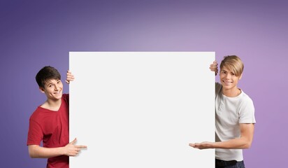 Smiling young holding white vertical advertisement board, demonstrating free copy space