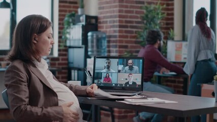 Pregnant employee using business video call on laptop to talk to workmates. Woman expecting baby and attending meeting on online remote video conference, talking about project planning. - Powered by Adobe