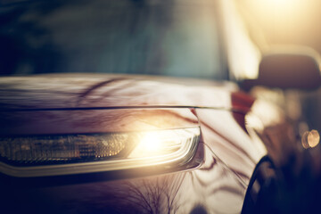 The car's headlight. Parked cars.