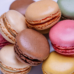 Stacked macarons of different flavors on a plate.