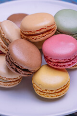 Stacked macarons of different flavors on a plate.