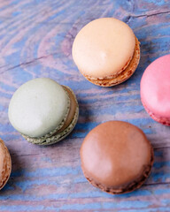 Stacked macarons of different flavors on an old wooden table.