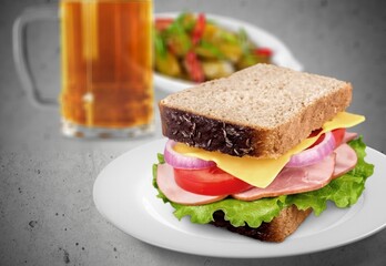 Sandwich with sausage and cucumber on desk in the room