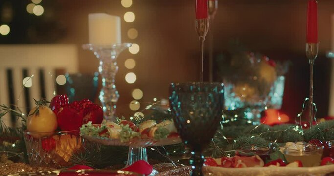 Festive Christmas Table with Dishes for celebrating Christmas with Fireplace on Background