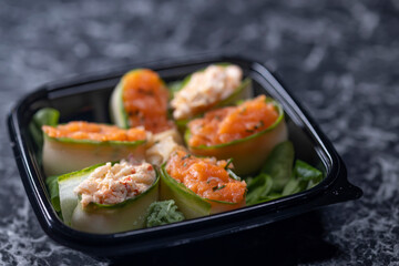 set of sushi rolls with seafood on a black stone background