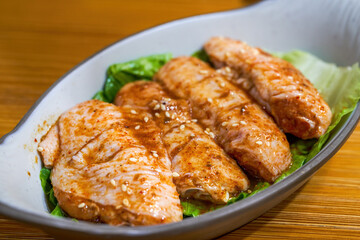 Closeup of a dish of marinated chicken wings barbecue ingredients