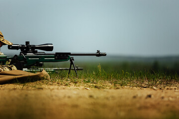 a sniper shoots lying down with a rifle with an optical sight