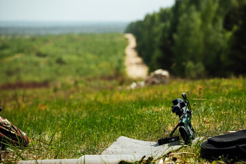 a sniper rifle is lying on the grass at a military training ground