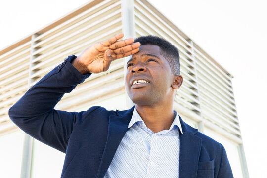 Black Man With Hand On Forehead Looking At Distance