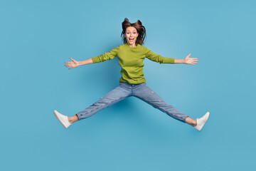 Fototapeta na wymiar Photo of cheerful amazed shocked lady jump open mouth wear green shirt jeans footwear isolated blue color background