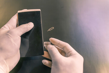 Man's hand in rubber protective , staff change SIM card, selling travel sim in a shop for customers...