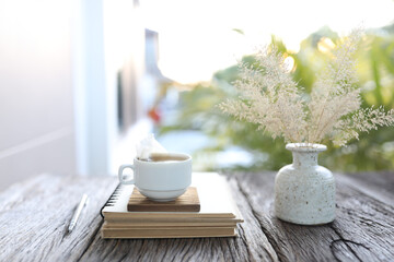 white cup with dry grass in a white vase