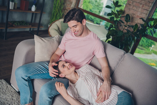 Portrait of attractive sweet cheerful spouses lying on divan daydream calm paceful holiday pastime staying at home indoors
