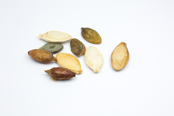 Different colorful  Dry Roasted Pumpkin seeds on white background. Tasty and healthy food. Close up...
