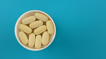 dose of pills with copy space. supplement tablets on a blue background. immune support supplement...