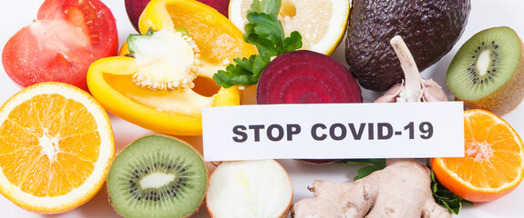 Inscription stop covid-19, fresh healthy fruits and vegetables containing vitamins. Immune boosting in times of Covid-19