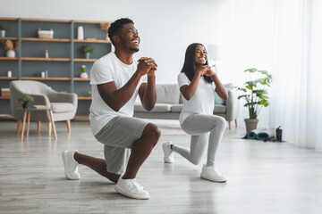 Young black couple doing forward lunges exercise - obrazy, fototapety, plakaty