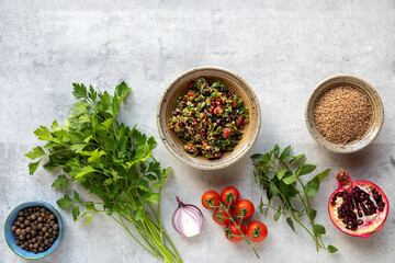 Tabbouleh salad with ingredients: bulgur, parsley, mint, pomegranate, lemon, tomato, onion,...